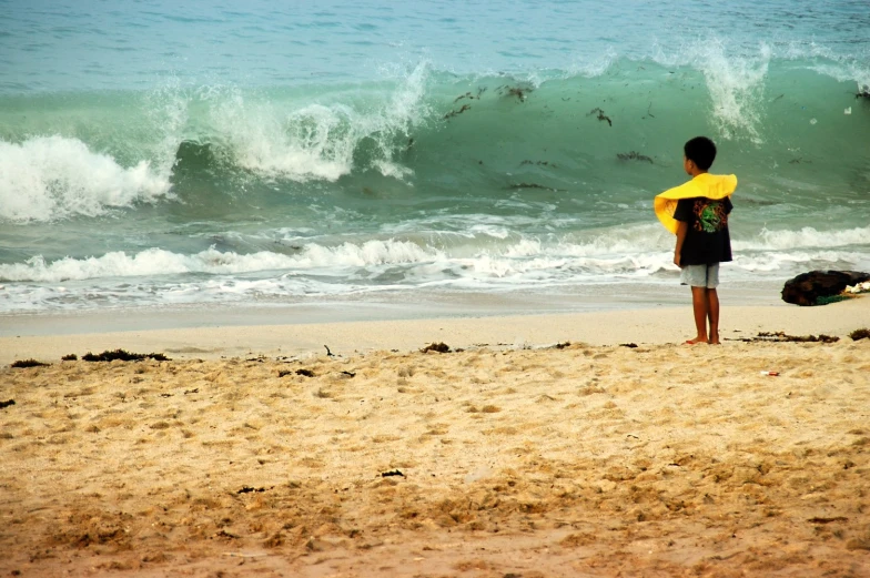 a  stands with his surf board on the beach