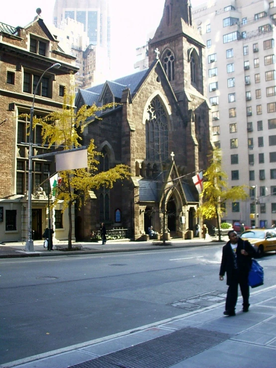 a man walking down the street in front of an old church