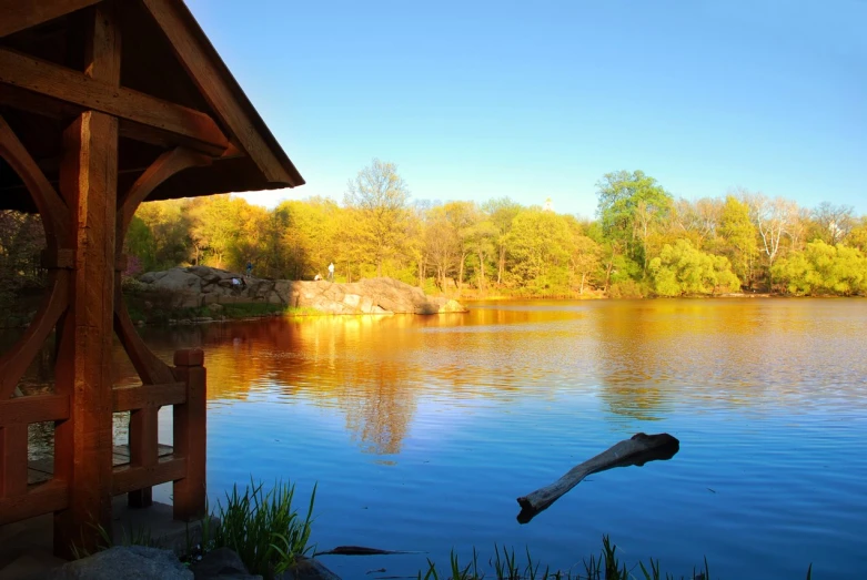 a small river next to a small cabin with a lake