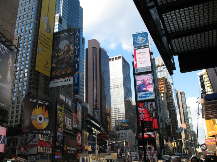 a busy city street full of people, buildings and billboards