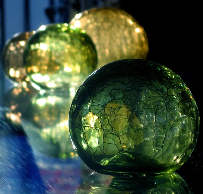 three glass balls with ed designs sitting in a room