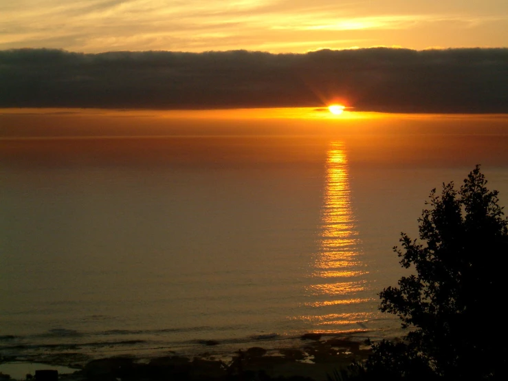 a view of the sun setting on the water