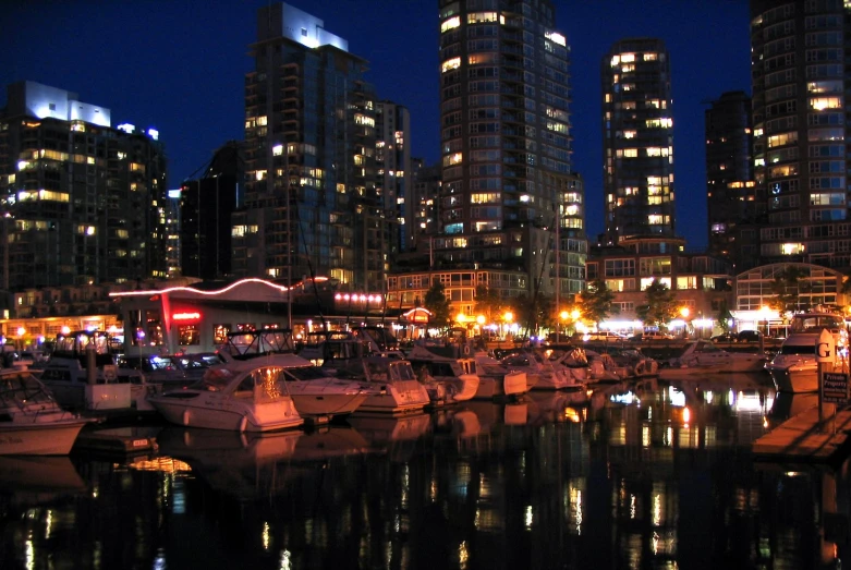 a city marina and city lights reflected in the water