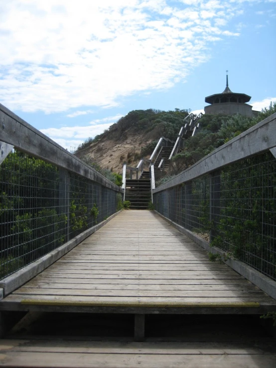 the wooden walkway is next to a steep hill