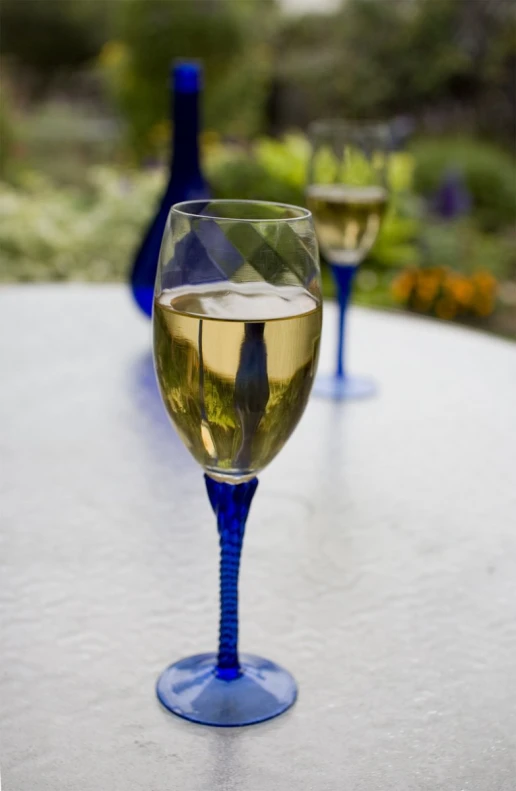 two blue wine glasses sitting next to each other on a table