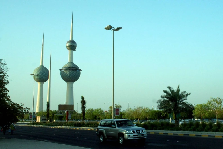 a grey four door truck drives past some large spires