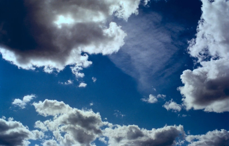 a jet airliner flying through the air near clouds