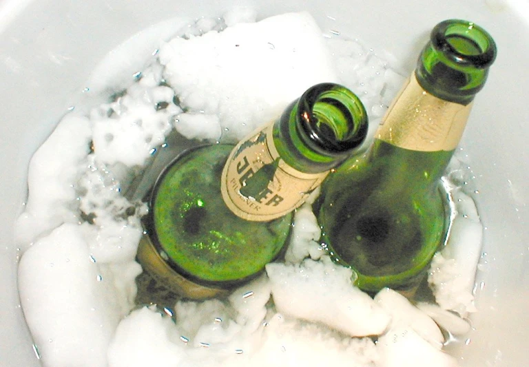 two wine bottles are sitting in a ice bucket