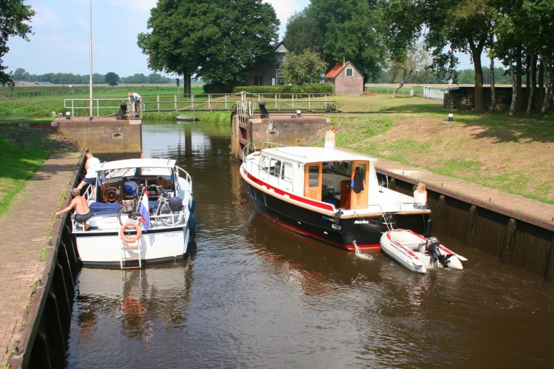 three small boats in a lock area near the water