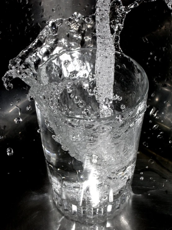 a drink being poured in the middle of a glass