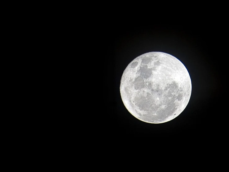 a large white moon in the sky with a dark sky