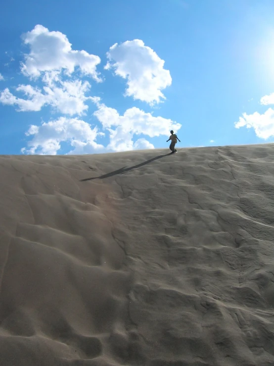 a person on top of a large sand hill