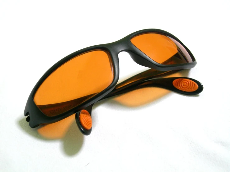 pair of sunglasses with a rubber frame and mirror lens resting on the surface