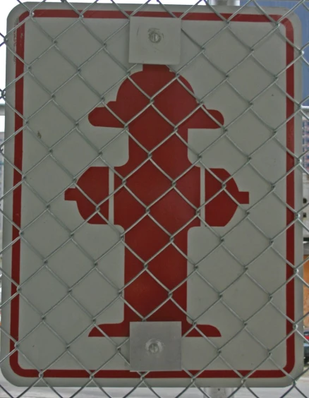 a white and red sign that is attached to a chain link fence
