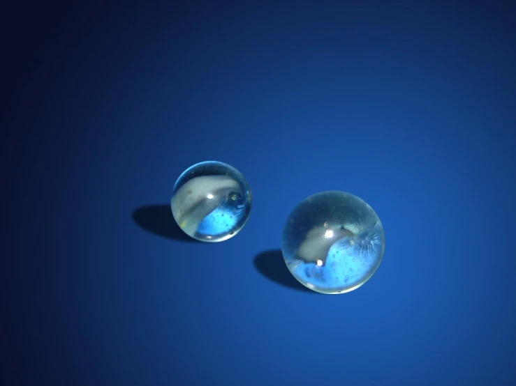 a pair of shiny balls that are against a blue background