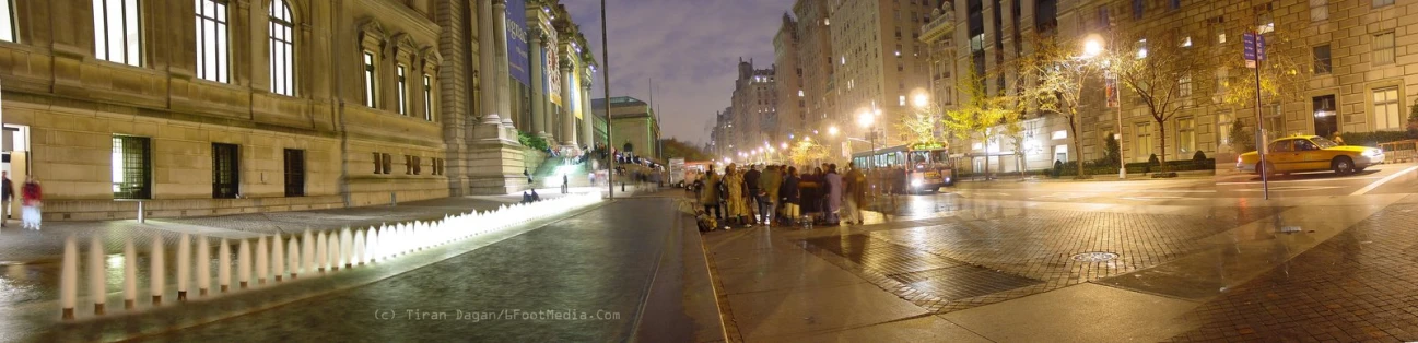 the city street is lit up with bright lights and buildings