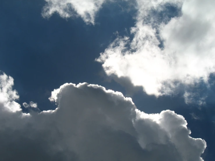 an airplane in the sky with a lot of white clouds