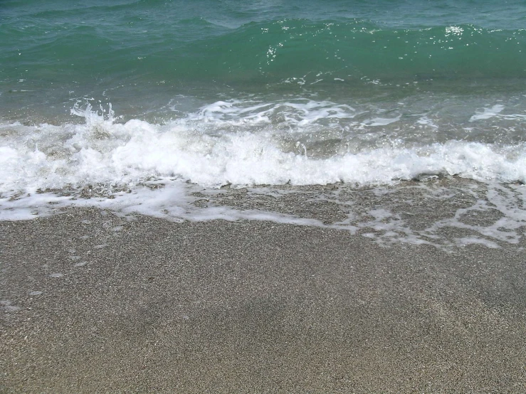 water breaking on a beach next to the shore