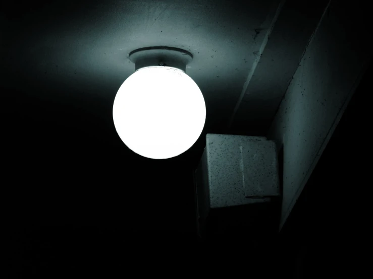 an illuminated orb ball hangs in the dark