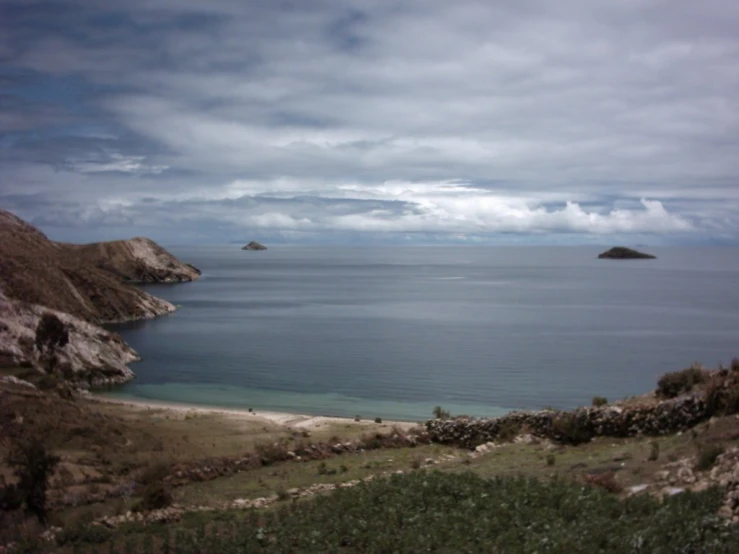 an island in the middle of water under cloudy skies