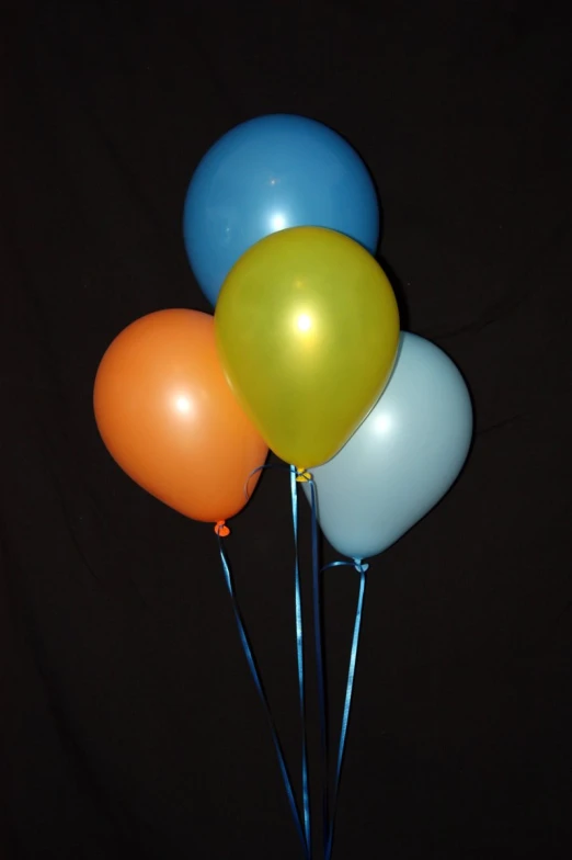 three balloons are on top of some sticks