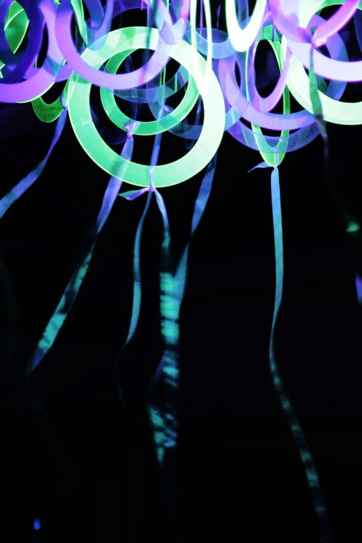 a bunch of green and purple streamers in the dark