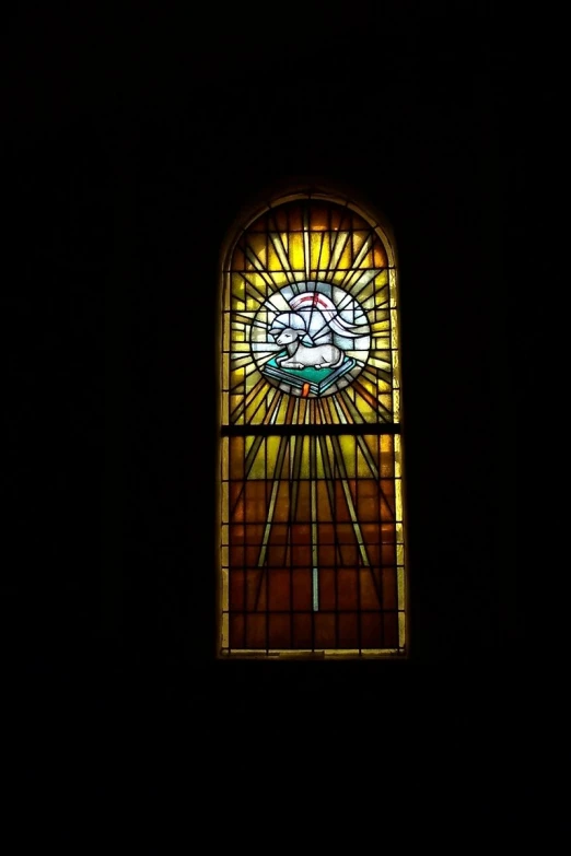 a very nice looking stained glass window in a dark room