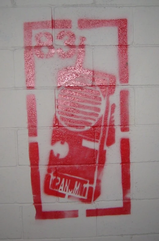 a red spray paint graffiti on the side of a wall