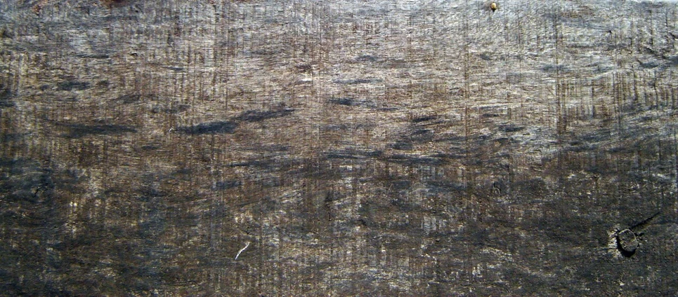 a worn piece of wood has several small scratches