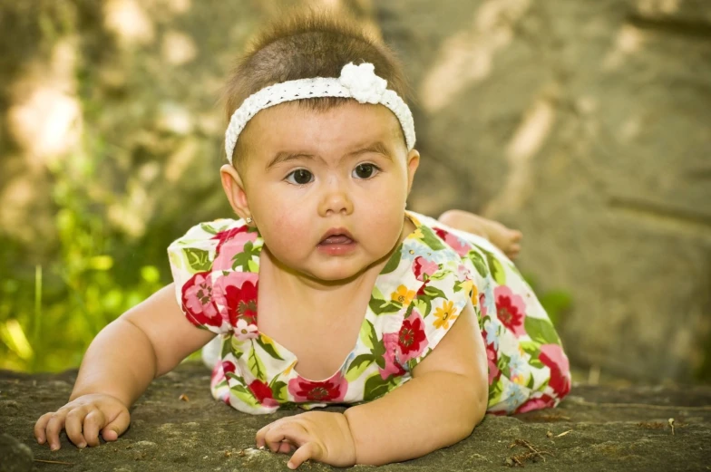 a small child laying on its stomach in a forest