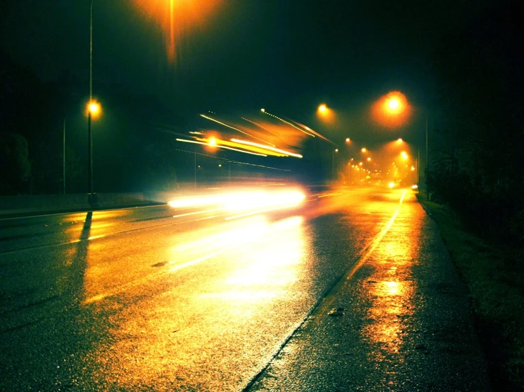 the car lights shine brightly on a street at night