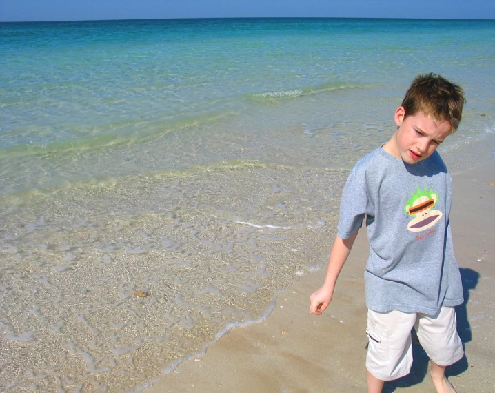 a  is standing on the beach with a sandwich