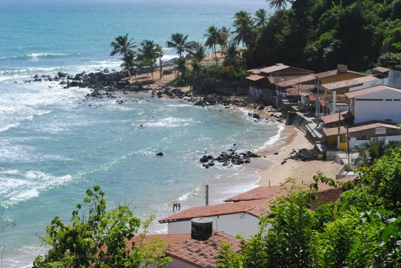 a sandy beach next to a town on the ocean