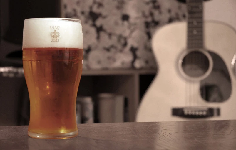 a drink in a glass with a guitar behind it