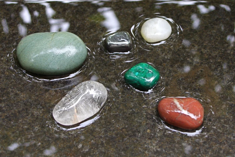 various stones on a marble surface with rain droplets