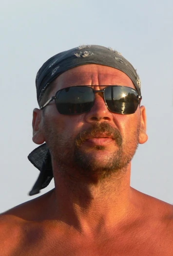 a man with  wearing sunglasses and with a bandana on his head