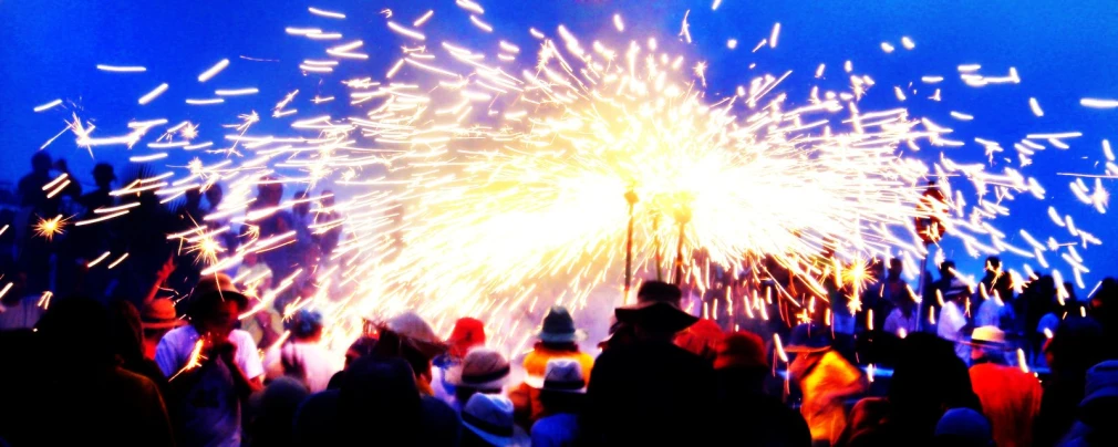 fireworks are being lit at the same time as people walk by