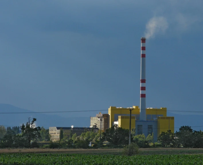 an industrial factory building with smoke billowing from the top