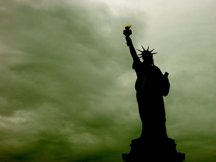 a view of the statue of liberty in a cloudy sky