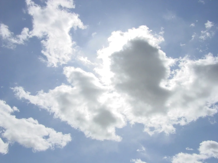 a cloudy blue sky with a heart shape cloud