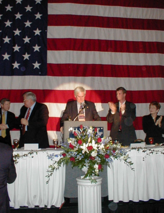 the people are at a political event, while a speaker is speaking