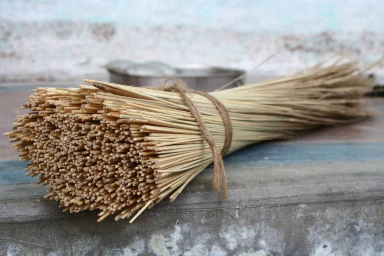 a bundle of straw and a metal bowl on top