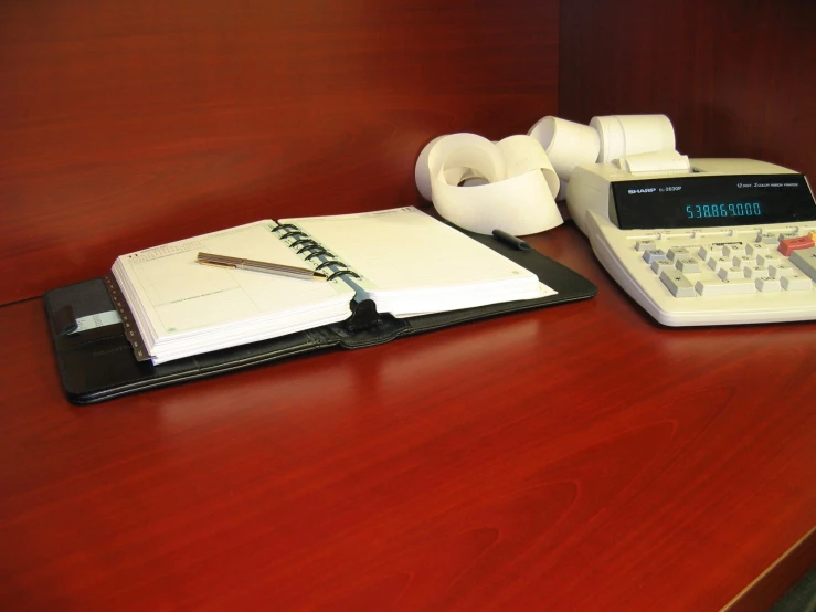 a book, headphones and cell phone are on a desk