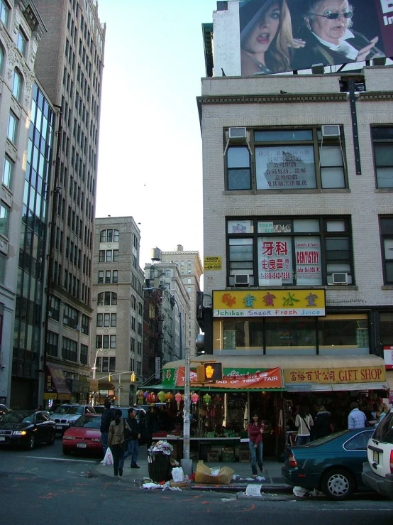 many cars are parked on the street in front of tall buildings