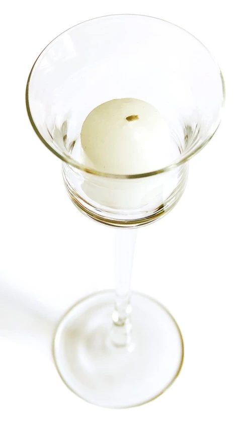 a martini in a tall glass with a white ball