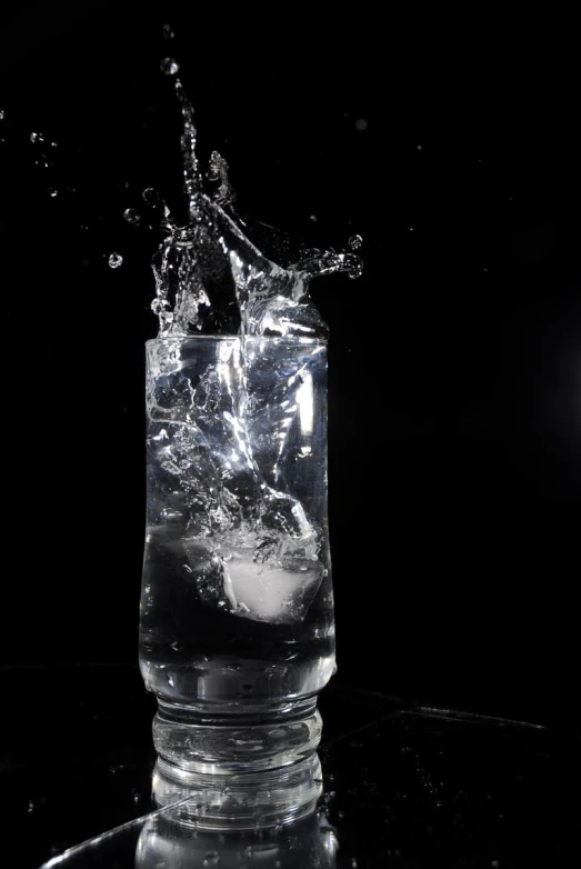 a glass full of water with ice on the rim