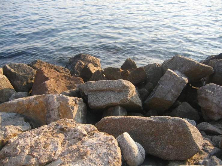 the rocks are by the water and clear