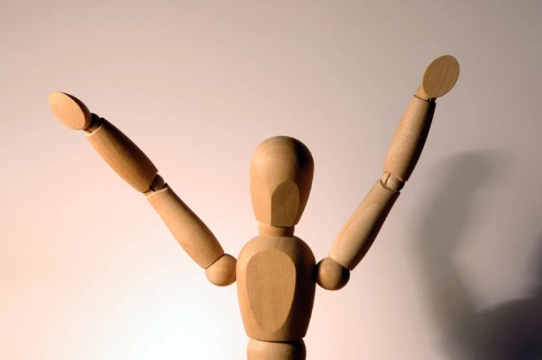 a wooden doll with one hand in the air