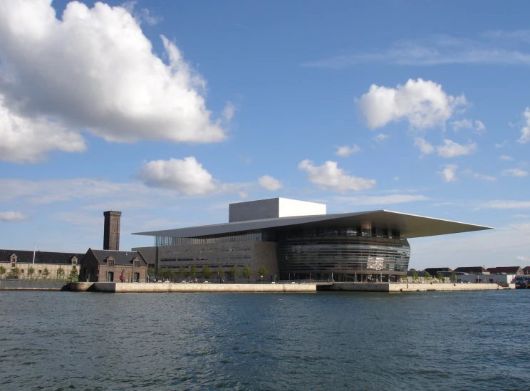 the building is on the shore with a large body of water behind it