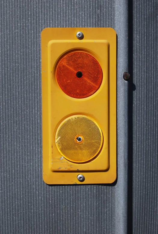 a yellow light on the side of a wall